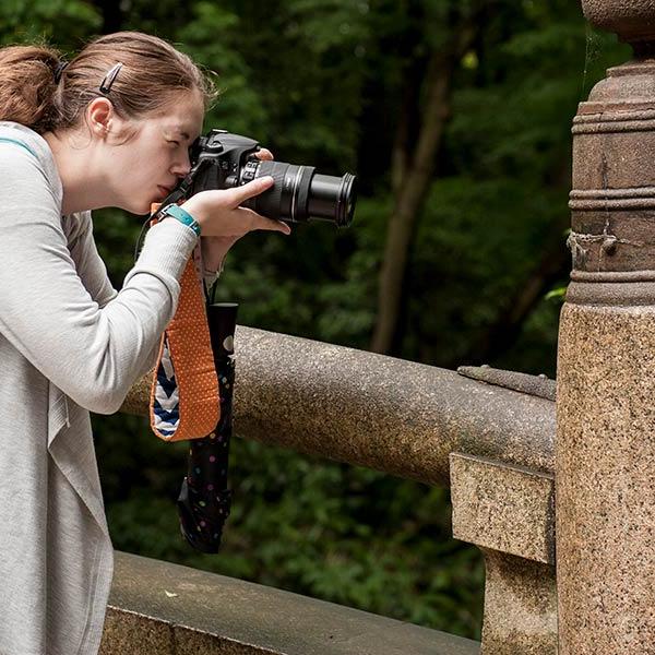 student taking a picture of insect 